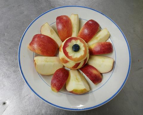 Illustrative photo: A red apple cut into wedges and arranged on a plate