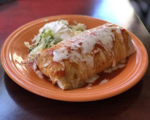 Illustrative photo: A burrito topped with melted cheese on an orange plate