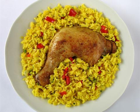 Illustrative photo: A roasted chicken leg on yellow rice with pieces of red pepper