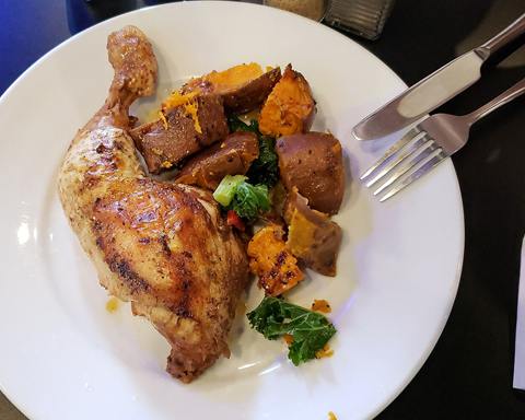 Illustrative photo: A roast chicken leg with roasted sweet potato and kale
