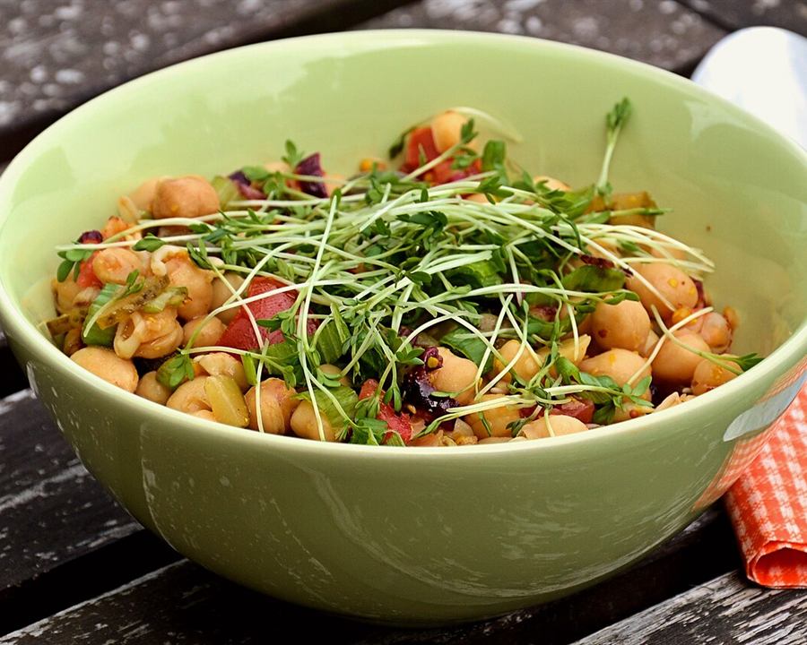 Illustrative photo: A green bowl of chickpea salad with cherry tomatoes and garden cress