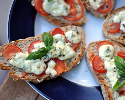 Illustrative photo: Toasted bread topped with tomato slices, soft white cheese and basil