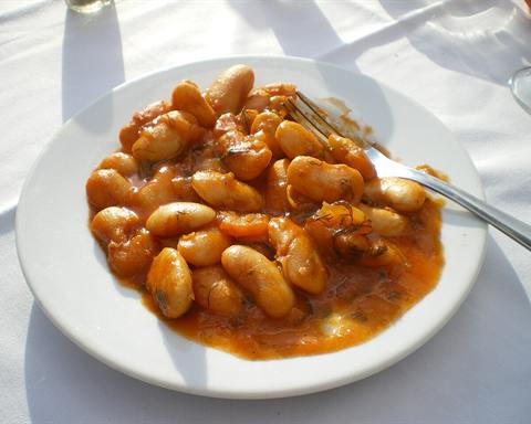 Illustrative photo: Giant white beans baked in tomato sauce on a white plate