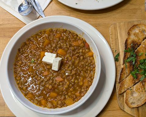 Illustrative photo: A bowl of lentil soup with a cube of feta, served with toasted bread