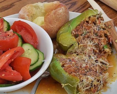 Illustrative photo: A stuffed green pepper with a savory filling, served with salad and potato