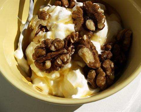 Illustrative photo: Greek yogurt drizzled with honey and topped with walnuts in a yellow bowl