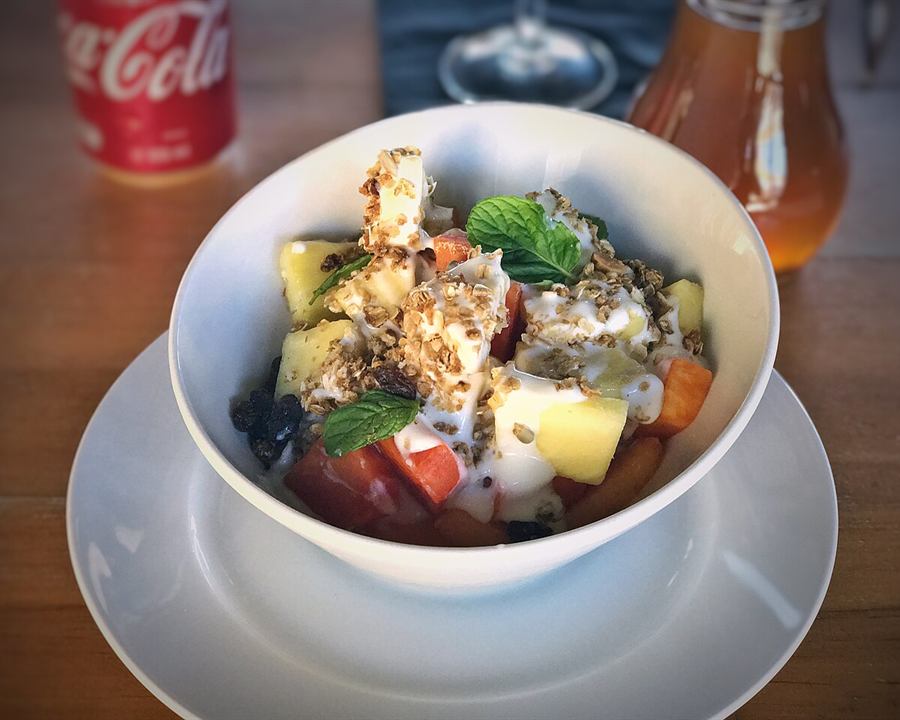 Illustrative photo: A white bowl of yogurt with pieces of fruit, granola and mint